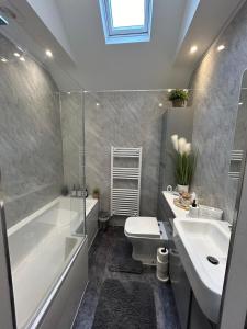 a bathroom with a tub and a toilet and a sink at Cannons Loft Central Buxton, Duplex loft 3 bedroom Set over 3 floors stairs no lift sleeps 5 in Buxton