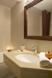 a bathroom with a sink with an apple on it at Ikia Luxury Homes in Gonia