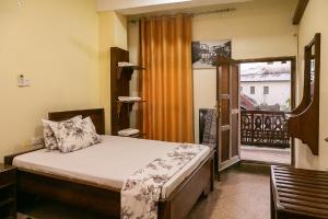a bedroom with a bed and a balcony at Zanzibar Town Nest Hotel in Zanzibar City