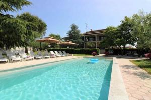 a swimming pool with chairs and an umbrella at Bungalow Melisa 8 in Poreč