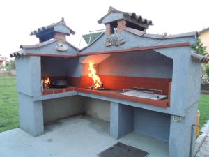 a outdoor pizza oven with a fire in it at Bungalow Melisa 8 in Poreč +12 photos
