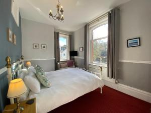 a bedroom with a white bed and a window at Goodwin House in Keswick