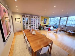 a dining room and living room with a table and chairs at ArticVieW Tromsø city centre in Tromsø