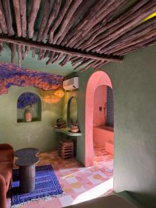 a living room with a table and a room with a ceiling at Casa Amina in Chefchaouene