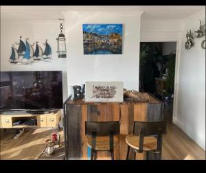 a living room with a table and chairs and a tv at Liberté Room Chambre privée en colocation conviviale ! in Nanterre