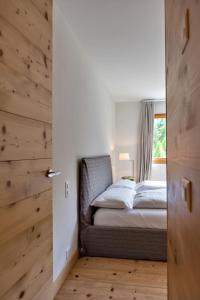 a bedroom with a bed and a window at Chesa Gravules - La Punt in La Punt-Chamues-ch