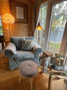 un soggiorno con divano e tavolo in vetro di Tiny House "Wolke 7" a Göhren-Lebbin