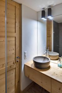 a bathroom with two sinks and a wooden door at Chesa Gravules - La Punt in La Punt-Chamues-ch +22 photos