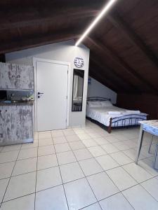 sypialnia z łóżkiem i białą podłogą wyłożoną kafelkami w obiekcie Lazarus Beach Sofitas w mieście Monemwasia