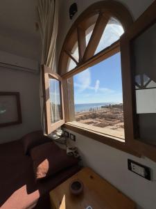 a room with a window with a view of the beach at Tokyo house hotel in Dahab