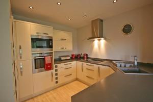 een keuken met witte kasten en een aanrechtblad bij Heatherlea Holiday Cottage in Otterburn