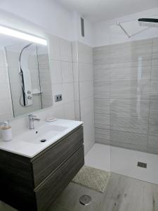 Un baño blanco con lavabo y ducha en Balcón de Puerto Naos, en Los Llanos de Aridane 18 fotos más