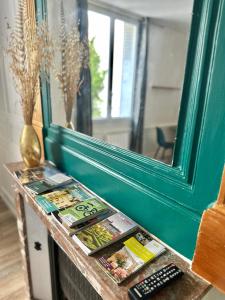 トゥールにあるCharmant studio à deux pas de la gareの雑誌を取り揃えたテーブル、鏡、リモコン