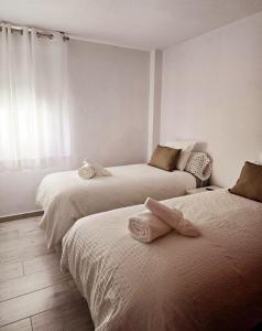 Un dormitorio con dos camas con toallas encima. en Balcón de Puerto Naos, en Los Llanos de Aridane