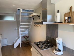 a small kitchen with a stove and a spiral staircase at Studio 8 in Zoutelande
