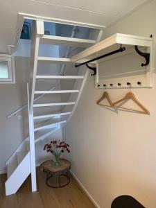 a white staircase in a room with a vase of flowers at Studio 8 in Zoutelande +12 photos