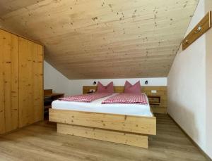een slaapkamer met een bed met rode kussens bij Ferienhof Hefele Ferienwohnung Breitenberg mit KönigsCard in Hopferau +19 foto's