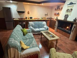 a living room with two couches and a fireplace at Casa rural Isi in Torrenueva