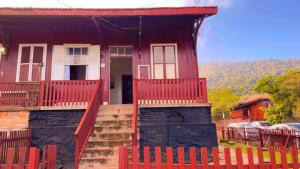 a red house with a red fence in front of it at Hostel Big Ben in Paranapiacaba
