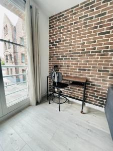 a desk and chair in front of a brick wall at La treille Vieux-Lille - 4 pers - Parking in Lille