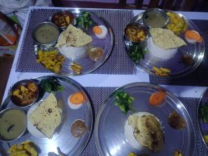 three plates of food on a table with eggs and vegetables at Bindabashini homestay house no 14 in Bandipur