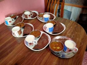 a table with plates of food and cups of coffee at Bindabashini homestay house no 14 in Bandipur