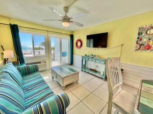 a living room with a couch and a tv at Starfish Villa in Panama City Beach
