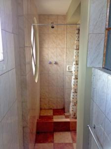 a bathroom with a shower with a red floor at Hostal Sauna Tambo Wasi in Huancayo +20 photos