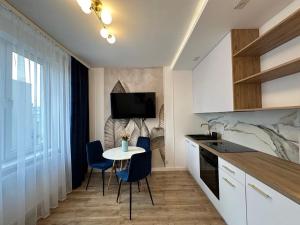 a kitchen with a small table and chairs in a room at Zgoda 5 Apartment in Gdynia