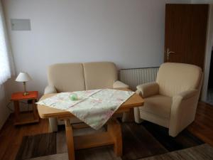 ein Zimmer mit einer Couch, einem Tisch und einem Stuhl in der Unterkunft Haus Hopp - Bungalow in Dahme