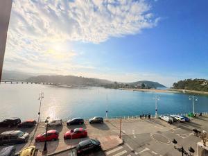 - un parking avec des voitures garées à côté d'une masse d'eau dans l'établissement Balcón de la ría de Ribadesella, à Ribadesella