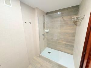 une douche avec une porte vitrée dans une salle de bain dans l'établissement Balcón de la ría de Ribadesella, à Ribadesella 12 autres photos