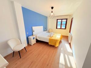 une chambre avec un lit, une table et une chaise dans l'établissement Balcón de la ría de Ribadesella, à Ribadesella