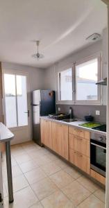 a kitchen with a sink and a refrigerator at Ma maison au bord de la mer in Saint-Hilaire-de-Riez