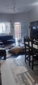 a living room with a couch and a television at Casa de veraneio in Caraguatatuba