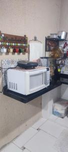 a microwave sitting on a shelf on a wall at Casa de veraneio in Caraguatatuba +1 photo