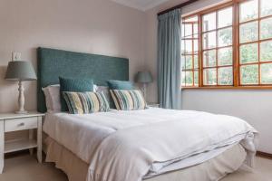 Un dormitorio con una gran cama blanca y una ventana en Sandown Estate Apartment en Johannesburgo