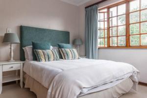 a bedroom with a large white bed and a window at Sandown Estate Apartment in Johannesburg
