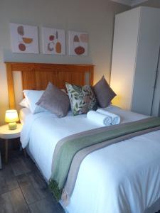 a bedroom with a large white bed with pillows at Sugarbird Nest in East London