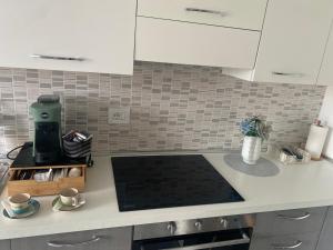 una cucina con mobili bianchi e un piano di lavoro di Gine's Tropea Home a Tropea Altre 9 foto