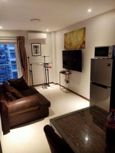 ein Wohnzimmer mit Sofa und Fernseher in der Unterkunft Sheryll Escapes - La Grande 406 cozy 1 bedroom Wi-Fi and Netflix in Angeles