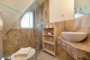 a bathroom with a sink and a toilet and a shower at Godeke Michels Ferienwohnung 23-Jonggöntje Seestr5b in Groß Kirr