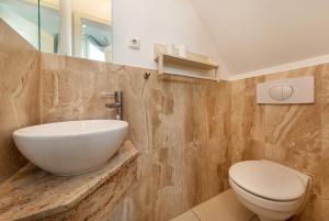 a bathroom with a sink and a toilet at Godeke Michels Ferienwohnung 23-Jonggöntje Seestr5b in Groß Kirr