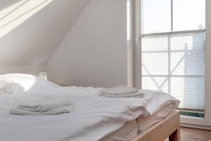 a white bed with two towels on top of it at Godeke Michels Ferienwohnung 23-Jonggöntje Seestr5b in Groß Kirr