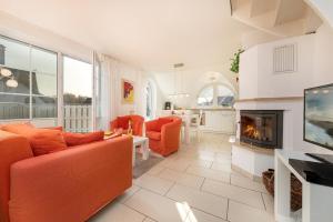 a living room with orange furniture and a fireplace at Godeke Michels Ferienwohnung 23-Jonggöntje Seestr5b in Groß Kirr