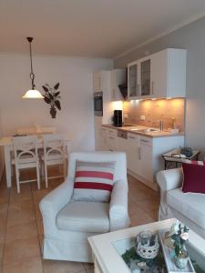 a living room with a white couch and a kitchen at Wellnessresidenz "Klaus Störtebeker" App6 in Zingst