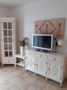 a white entertainment center with a flat screen tv on it at Wellnessresidenz "Klaus Störtebeker" App6 in Zingst