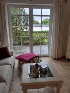 a living room with a coffee table and a large window at Wellnessresidenz "Klaus Störtebeker" App6 in Zingst