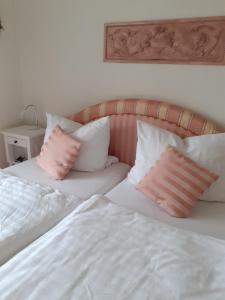 two beds with pink and white pillows next to each other at Wellnessresidenz "Klaus Störtebeker" App6 in Zingst +5 photos