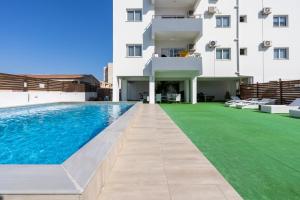 a swimming pool in front of a building at Snobby 2-Bedroom Apartment in Larnaca